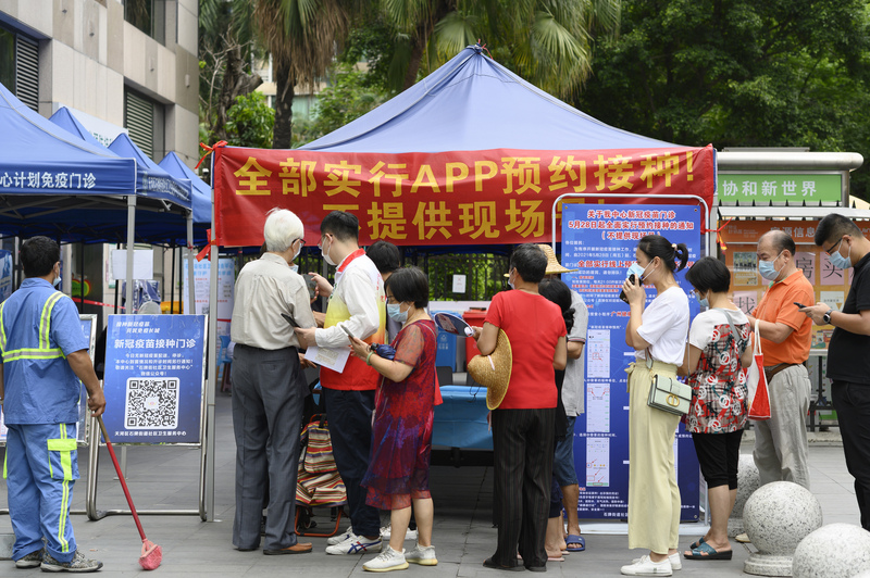 中國廣東省廣州市疫情持續延燒，廣州南沙區5日宣布全區所有公共交通工具停運。圖為廣州市民日前在社區衛生服務中心諮詢疫苗預約流程。(中新社提供 / 圖:中央社)