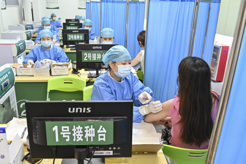 中國廣東省廣州市的本土COVID-19疫情持續蔓延，官方暫停一般民眾接種疫苗，讓醫護等重點人員優先施打。圖為5月30日廣州市海珠區的廣一電子商務產業園，官方安排為重點人員接種疫苗。（中新社提供） (圖：中央社)