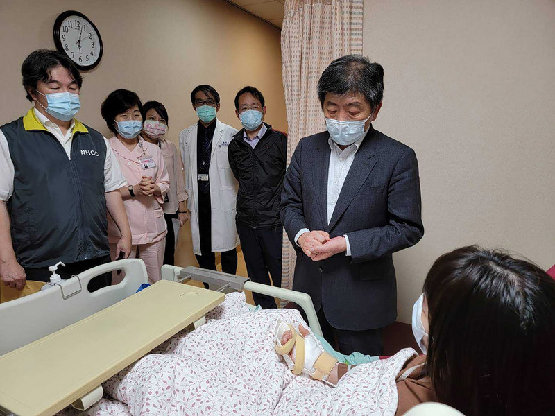 雙和醫院日前發生3名護理師遭武漢肺炎確診患者持刀砍傷事件，衛福部長陳時中（立者右）2日傍晚親自到醫院病房探視受傷護理師，表達慰問。（王必勝醫師提供） (圖：中央社)