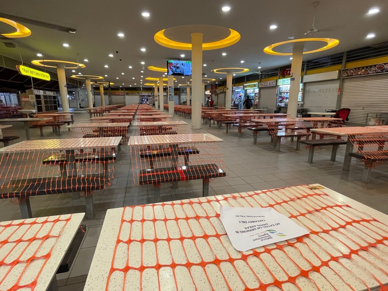 新加坡防疫升級，禁止餐廳及小販中心內用，圖為中峇魯熟食中心的桌椅套上繩索，以防有民眾坐下。攝於5月22日。 (圖：中央社)