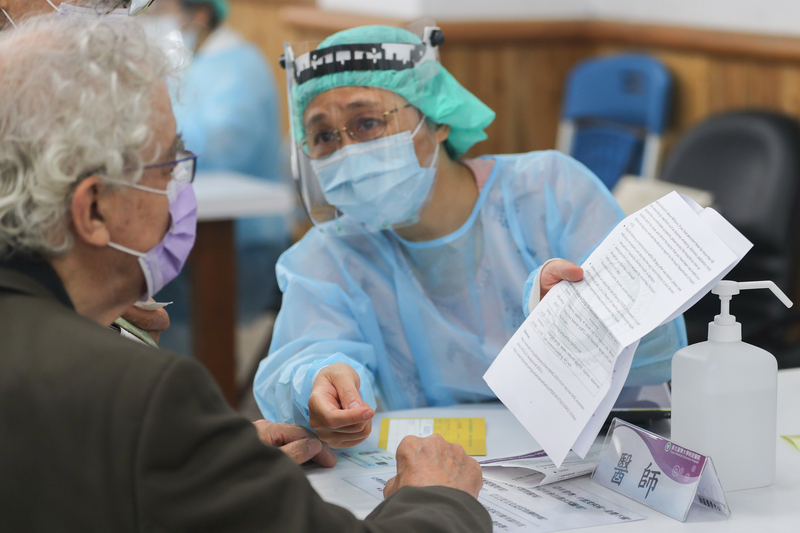台灣的健保制度與醫療服務深受留學生與在台外籍人士肯定。圖為疫情期間醫護人員向外籍人士提供看診時的英文注意事項。 (圖：中央社資料照片)
