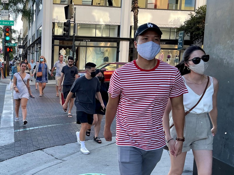 美國加州6月15日解除各項防疫規定，洛杉磯地區的部分行人仍自主戴著口罩。另為對抗Delta病毒，洛杉磯郡衛生局當地時間29日建議居民，只要進入室內就要戴口罩。 (圖：中央社)