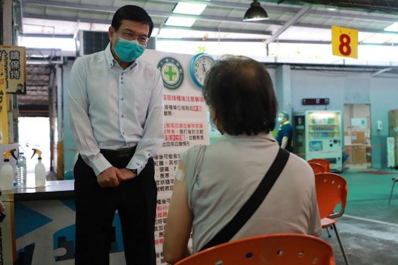 國內COVID-19疫情嚴峻，交通部長王國材（左）2日親自到濱江計程車服務站瞭解運輸業人員疫苗施打狀況。 (圖：中央社)