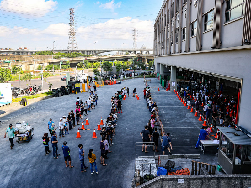 台北市疫情升溫，環南市場有41名攤商核酸檢測（PCR）為陽性，北市府立即啟動緊急處理機制，3日上午也擴大篩檢作業，現場安排動線讓民眾依序排隊篩檢。 (圖：中央社)