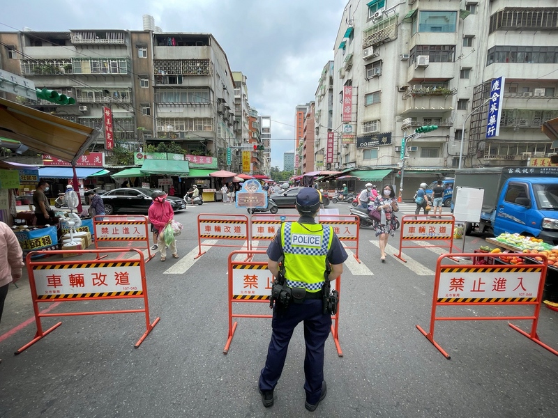 因應COVID-19疫情，全台第三級警戒延長至7月12日，台北市濱江市場在分流管制後人潮已明顯減少，圖為8日上午警察在主要道路口設柵欄管制人流。 (圖：中央社)