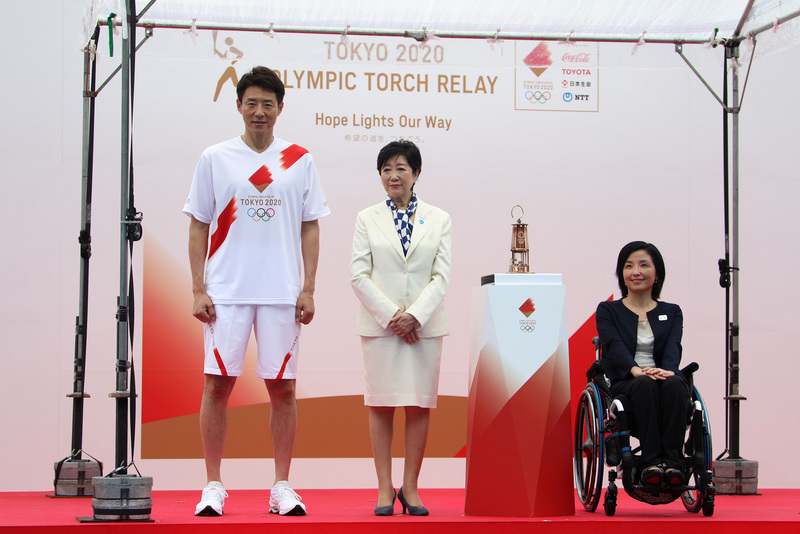 東奧聖火9日抵東京，東京都知事小池百合子（中）在聖火公開儀式上表示，全國人民以強烈的意念和努力克服了嚴峻的狀況，聖火代表「希望之路」延續傳遞至此。 (圖：中央社)