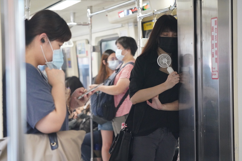 中央流行疫情指揮中心宣布全國三級警戒延長至26日，13日起放寬部分場域規定進行「微解封」。民眾搭乘捷運上班，靠在車廂內閉目養神。 (資料照片／中央社)