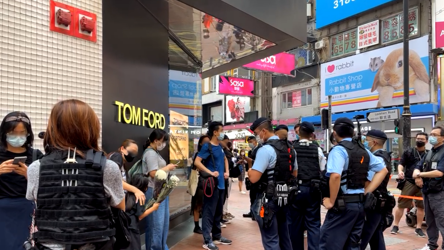 7月2日香港銅鑼灣崇光百貨外有大量市民被截查。包括攜帶白鮮花欲悼念的母親及女童，還有獨立記者。(圖：立場新聞提供)