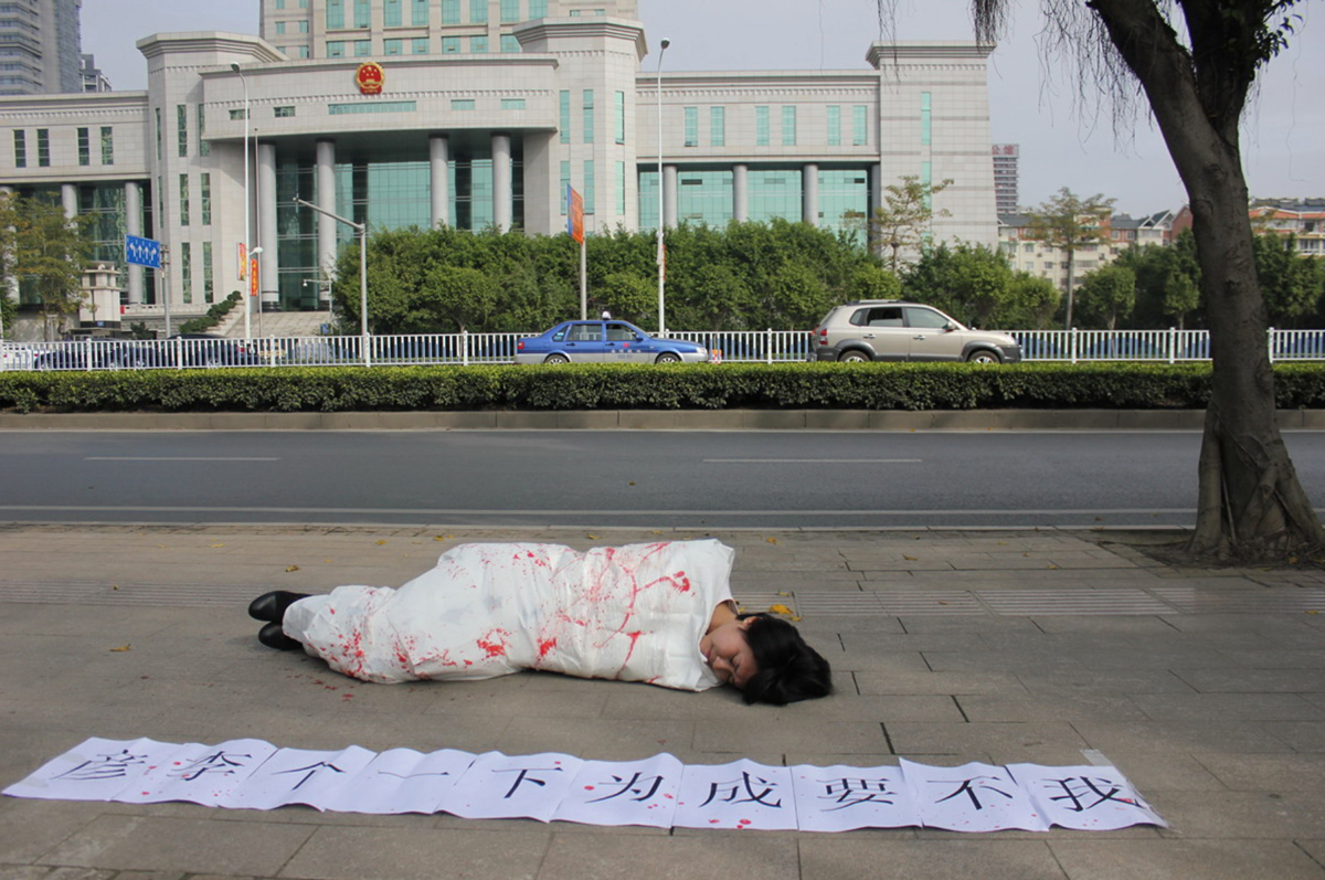 志願者在廣州、上海、武漢、北京、西安共八城法院門前同步公開行為藝術：「我不要成為下一個李彥」（資料照/取材自網路）