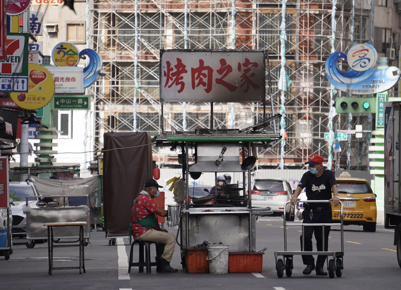 全台27日起至8月9日疫情警戒標準將降為2級，3級警戒期間靠外送、外帶苦撐的餐飲業者，在遵守相關指引下有望開放民眾內用。圖為攤販23日下午推著攤車到高雄六合夜市擺攤。 (圖：中央社)