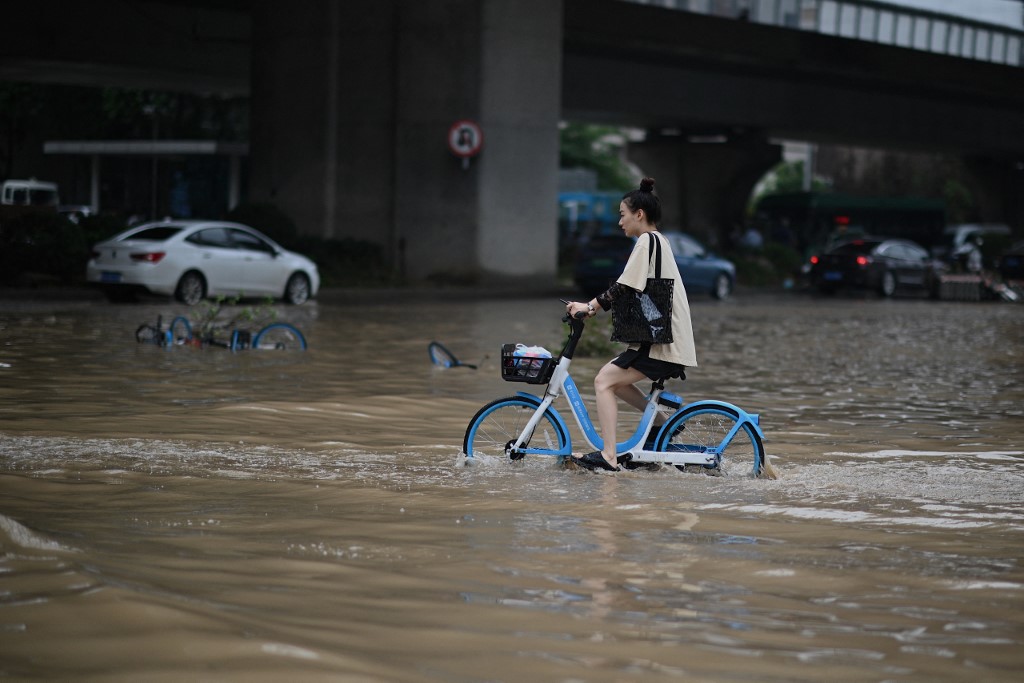 河南鄭州20日大暴雨後，水、電、網路全無，共享單車難以成功掃碼解鎖騎乘。(AFP)