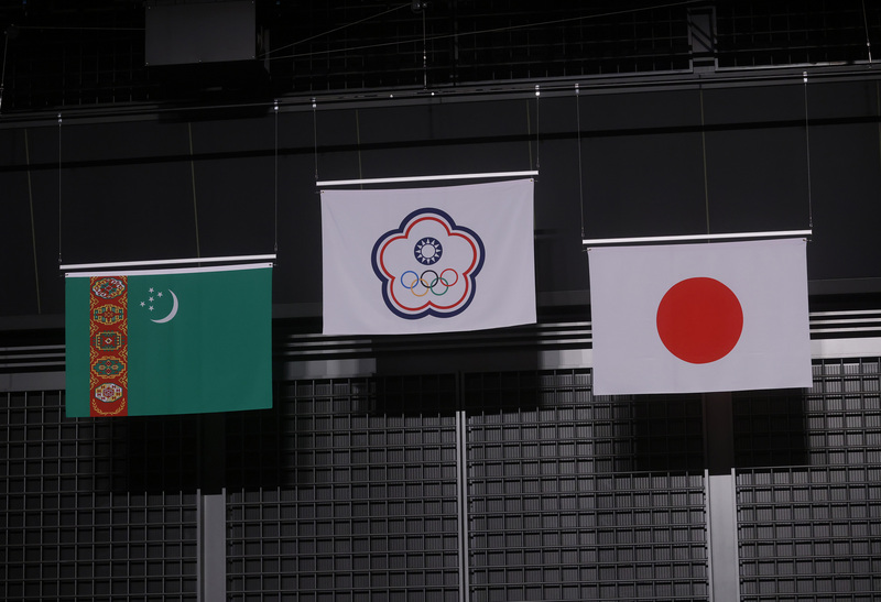 台灣舉重女將郭婞淳（右）27日順利拿下東京奧運女子舉重59公斤級金牌，也是台灣本屆奧運首面金牌，賽後中華隊旗在場中高高升起，兩旁則是分別獲得銀牌、銅牌的土庫曼及日本國旗。 (圖：中央社)