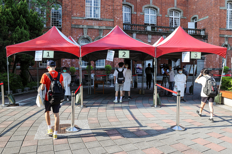 因COVID-19疫情延後的110學年度指定科目考試28日登場，考生進場前，分流排隊測量體溫。 (圖：中央社)