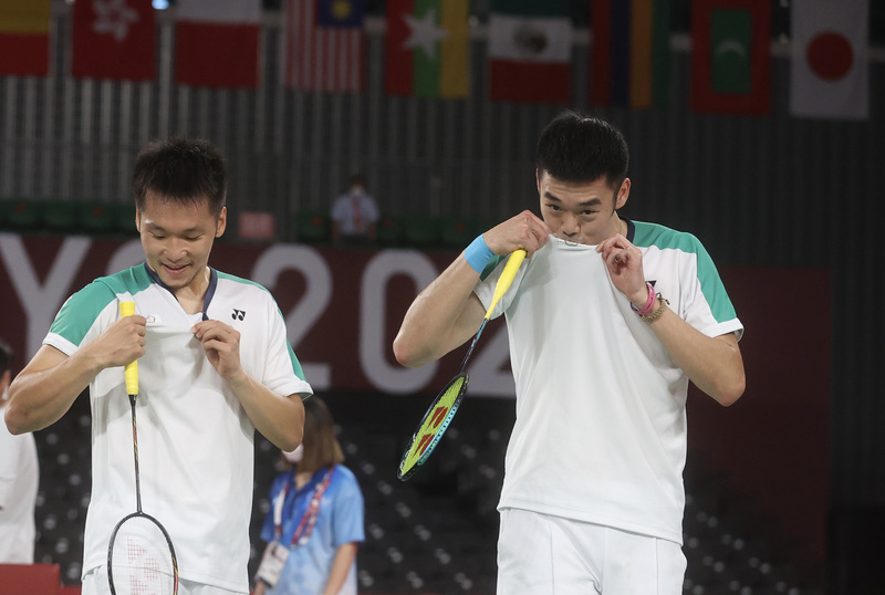 台灣好手又在奧運舞台寫下歷史一頁，羽球男雙搭檔李洋（左）、王齊麟（右）一路從小組賽差點出局，打到冠軍戰奪金，過程中更陸續打掉前4種子，讓世界成功看見台灣；在奪金後，王齊麟開心親吻隊服上的中華隊徽。 (圖：中央社)