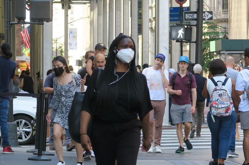 紐約近期COVID-19病例激增，官員呼籲已接種疫苗民眾在公共室內場合戴口罩，曼哈頓第五大道的行人也戴口罩防疫。 (圖：中央社)