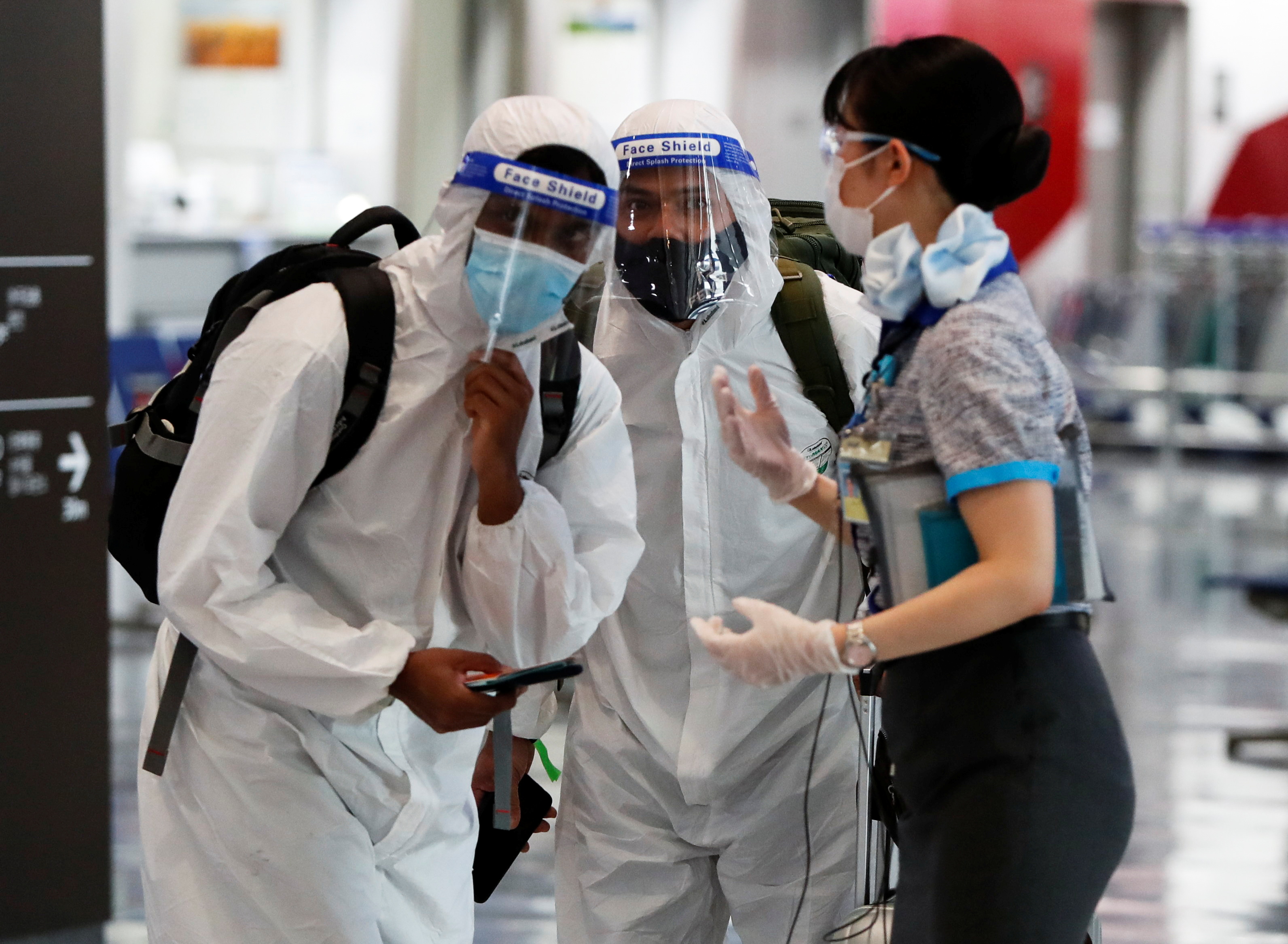 日本已確定將延長邊境管制措施。圖為成田機場地勤人員向入境旅客解說相關事項。(路透社/達志影像)