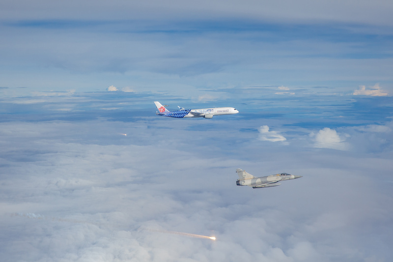 台灣選手在今年東京奧運成績亮眼，軍方下午安排4架幻象2000戰機，在空中迎接搭載羽球男雙奪金的王齊麟、李洋、羽球女單奪銀的戴資穎等人回台的華航班機，並施放熱焰彈（圖中發亮處）。（軍聞社提供） (圖：中央社)
