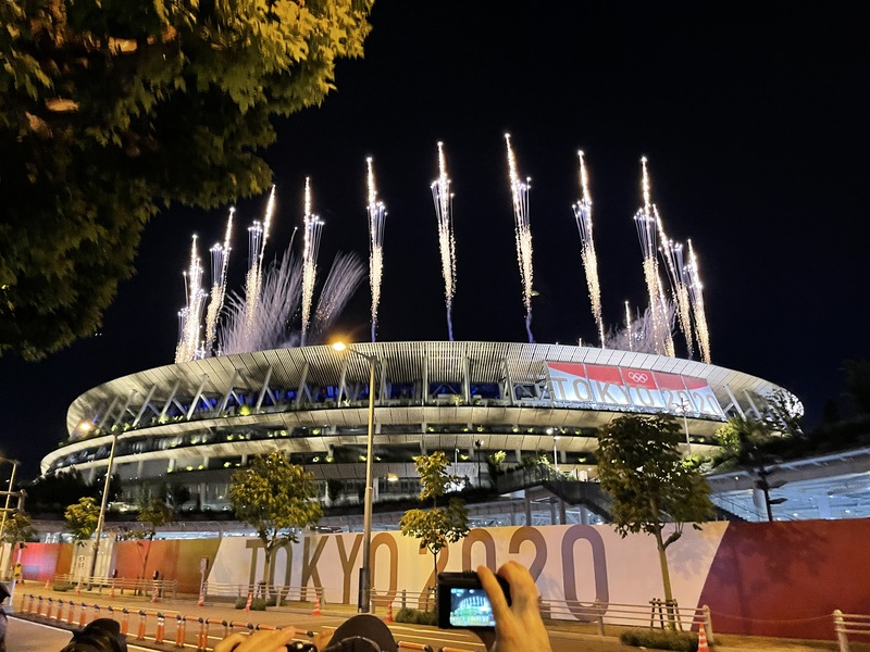東京奧運8日舉行閉幕式，主場館國立競技場外圍擠滿等待閉幕式的民眾，閉幕式以煙火揭開序幕。 (圖：中央社)