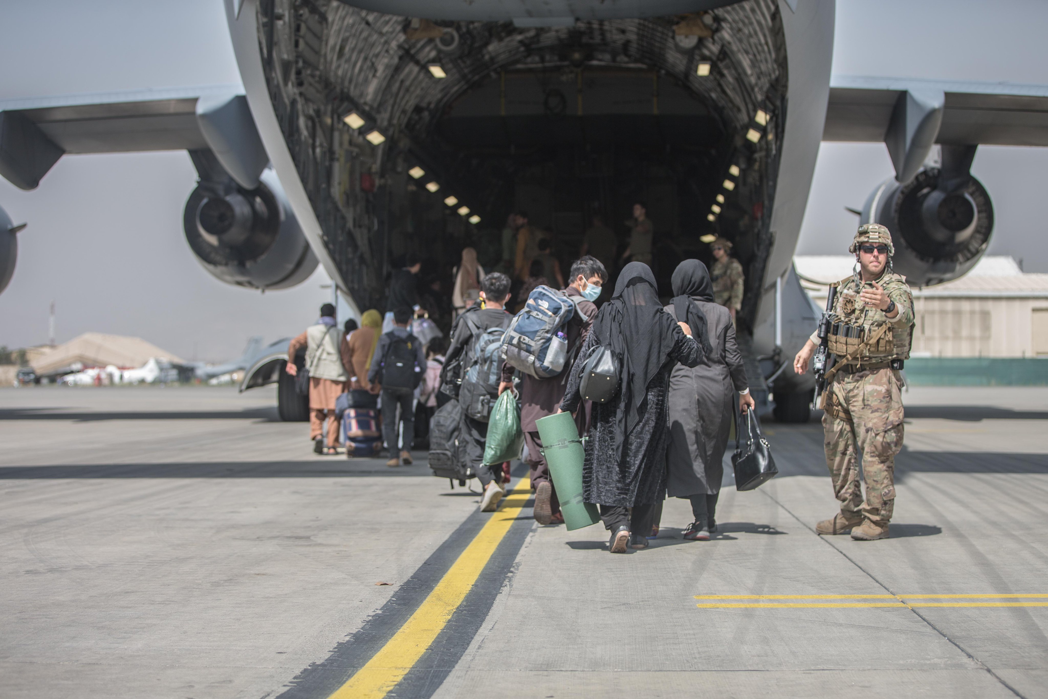 圖為阿富汗民眾登上美軍C-17運輸機。 (圖:美國防部推特)