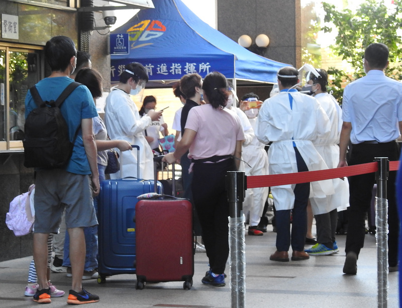 新北市某社區大樓爆發Delta變異株疫情，市長侯友宜9日表示，該大樓共785位住戶篩檢結果全是陰性。圖為社區居民8日帶行李在中庭等待專車接送。(中央社)