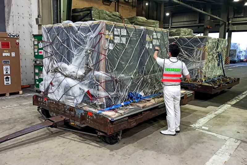 首批客製化標籤約55萬劑輝瑞BNT疫苗30日上午運抵台灣，經送往貨物碼頭，由海關人員查驗。（讀者提供） (圖：中央社)