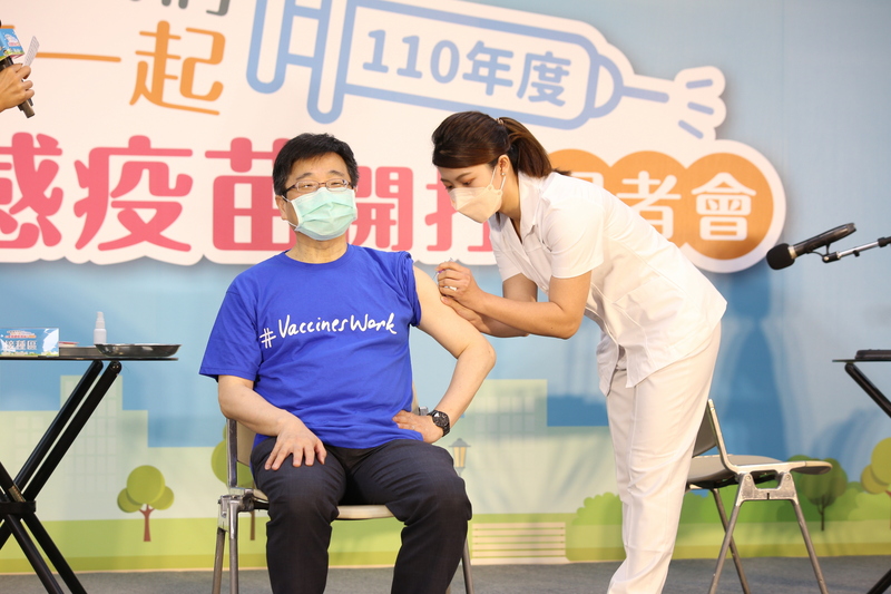 流感和COVID-19雖是不同疾病，但美國研究發現，接種流感疫苗可降低24%染COVID-19風險，住院率、重症率也減少40%以上。衛福部疾管署署長周志浩（左）1日挽袖接種流感疫苗。（衛福部疾管署提供）