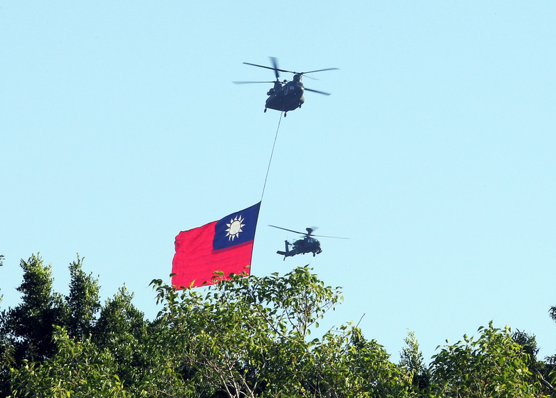 雙十國慶將至，國軍及空勤總隊5日上午再次進行空中全兵力預演，CH-47運輸直升機吊掛18公尺乘12公尺、史上最巨幅國旗通過台北市上空。(圖：中央社)