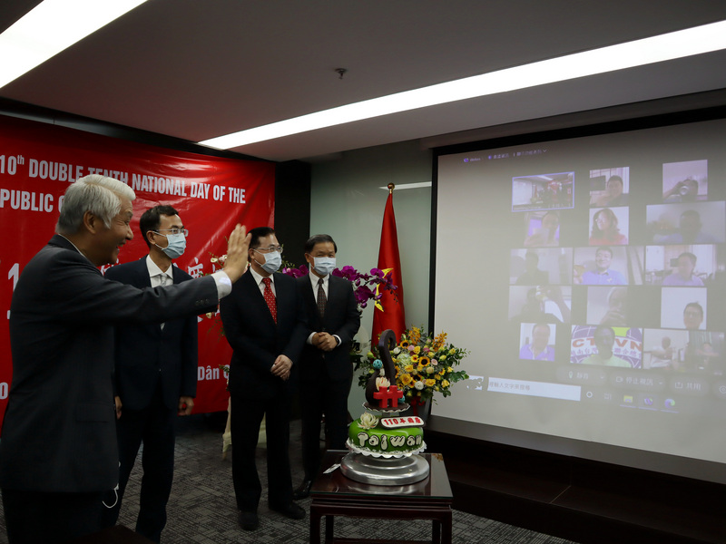 駐越南代表處8日舉行國慶酒會，在越南現行的COVID-19防疫規定下，駐越南代表石瑞琦率領代表處各組組長在線下慶祝，約百名台商、企業代表從各地連線同歡。圖為石瑞琦向台商、企業代表揮手問好。 (圖：中央社)