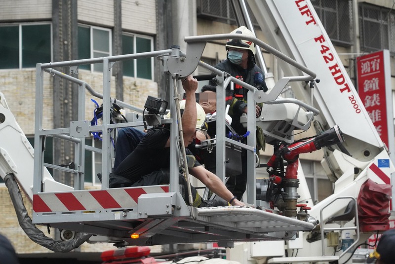 高雄市鹽埕區府北路城中城大樓14日凌晨發生火災事故，高雄市消防局出動雲梯車逐樓搜索，救出受困民眾。 (圖：中央社)