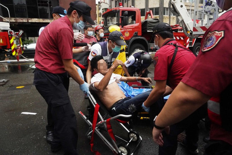 高雄市鹽埕區府北路城中城大樓14日凌晨發生火警，消防人員趕赴現場，將受困民眾救出送醫。 (圖：中央社)