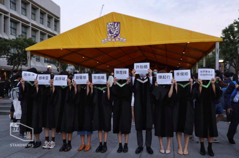 香港中文大學4日舉行畢業典禮，傍晚有多名畢業生手舉因反送中被捕同學名字在校園快閃，呼籲大家別忘記他們。（立場新聞提供）