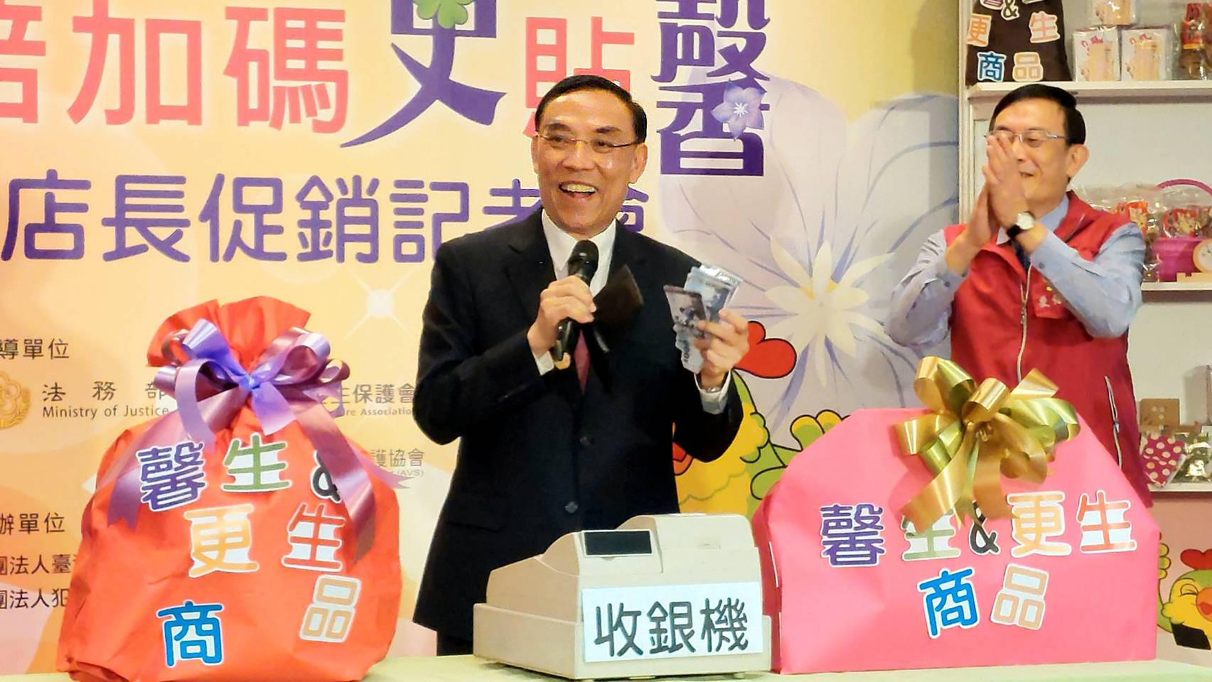 法務部長蔡清祥(左)掏出現金，要購買商品支持馨生人、更生人。(歐陽夢萍 攝)
