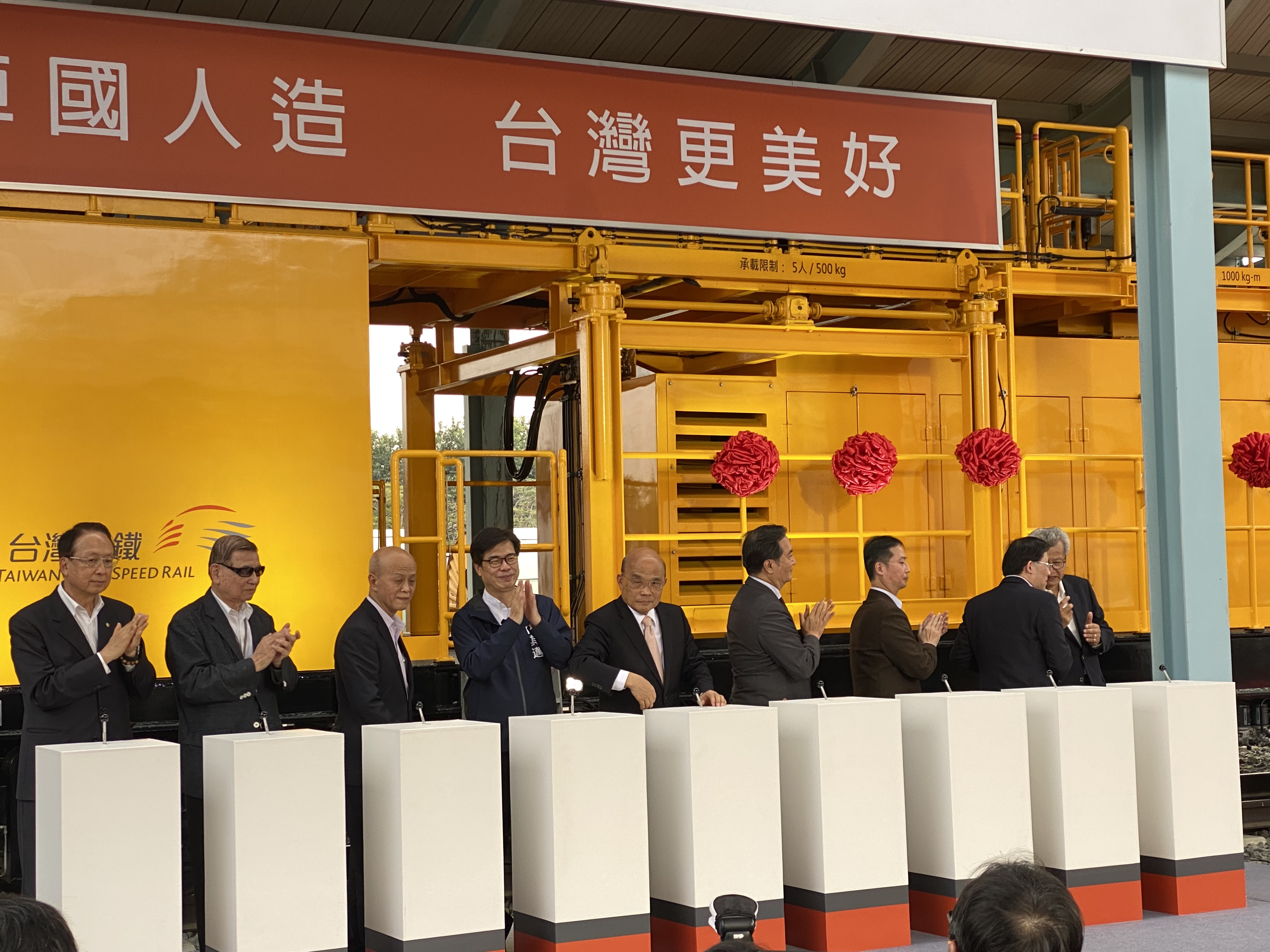 高鐵董座江耀宗(左)26日攜手中鋼董座翁朝棟(右)，在行政院長蘇貞昌(中)、行政院發言人羅秉成(右4)、交通部次長胡湘麟(左3)、經濟部次長林全能(右2)以及高雄市長陳其邁(左4)等人見證下，為「高鐵電車線維修工程車」舉行啟動儀式。(吳琍君 攝)