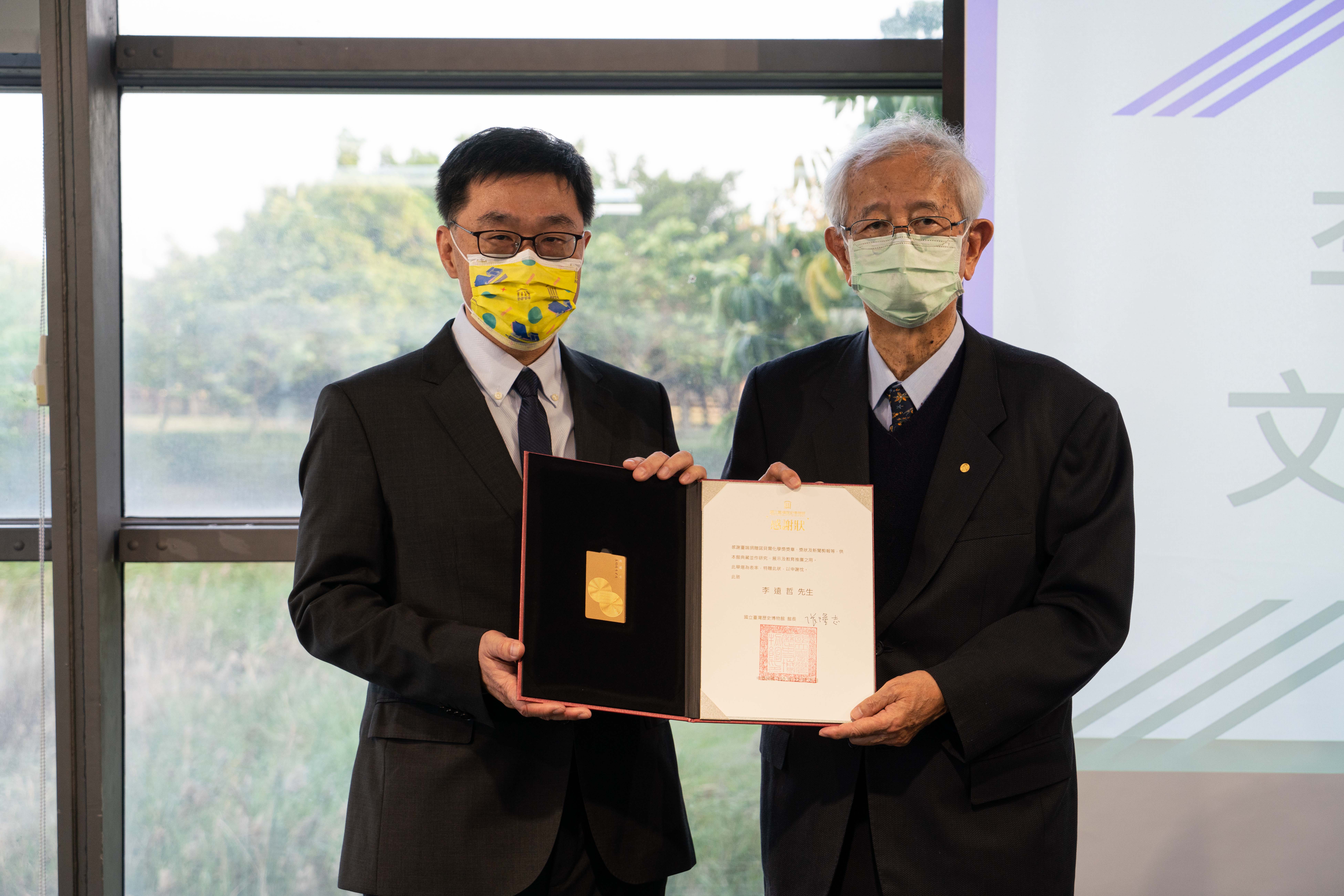 臺史博館長張隆志(左)親自頒贈感謝狀及臺史博「典藏卡」給予李遠哲，感謝前中研院院長李遠哲(右)捐贈諾貝爾獎章予相關學術獎章。(臺史博提供)