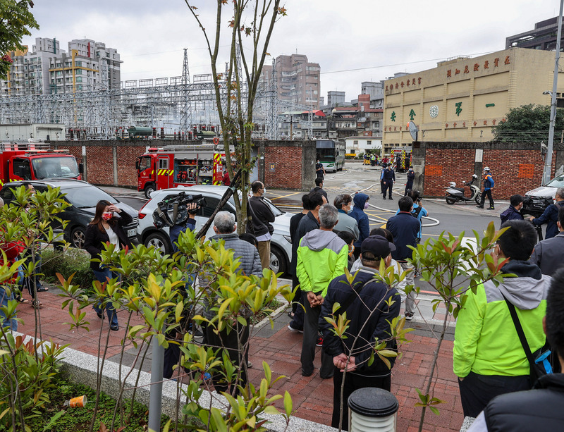 台北市文山區景隆街的萬隆變電所12日上午變壓器故障，一度傳出爆炸聲響，現場濃煙竄起，並造成部分地區停電，許多居民到場關心。(圖：中央社)