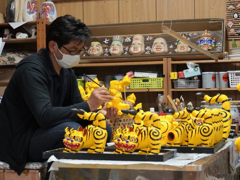 日本東北地區福島縣郡山市的高柴DEKO屋敷以製造木馬三春駒和紙偶三春張子聞名，這裡僅存4家紙偶工坊，圖為本家大黑屋負責人橋本彰一忙著製紙偶腰高虎。(圖：中央社)