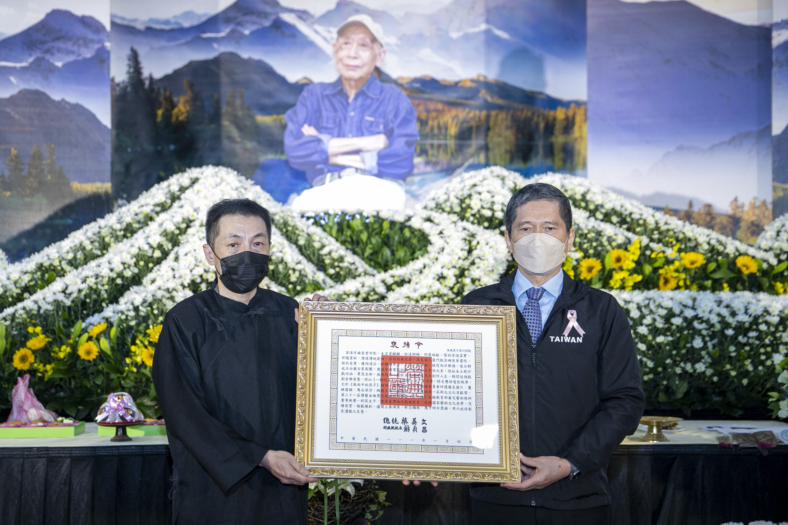 文化部長李永得(右)代表頒贈總統褒揚令，由曾仲影老師之長子曾英峰(左)代表受贈。(文化部提供)