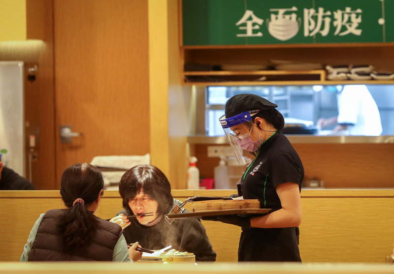 蘇貞昌：餐飲業牽涉190萬人生計 不禁止內用。圖為餐飲業服務人員配戴防護面具及口罩送餐。 (圖：中央社)