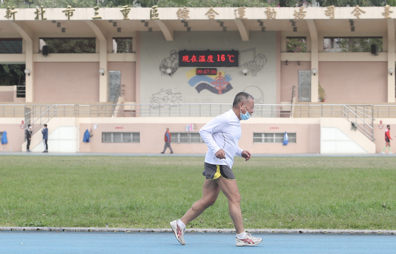 中央氣象局表示，14日受強烈大陸冷氣團持續影響，白天北部及宜花高溫僅攝氏16至18度，整天氣溫偏冷。圖為民眾上午不畏寒冷在運動場慢跑。 (圖：中央社)