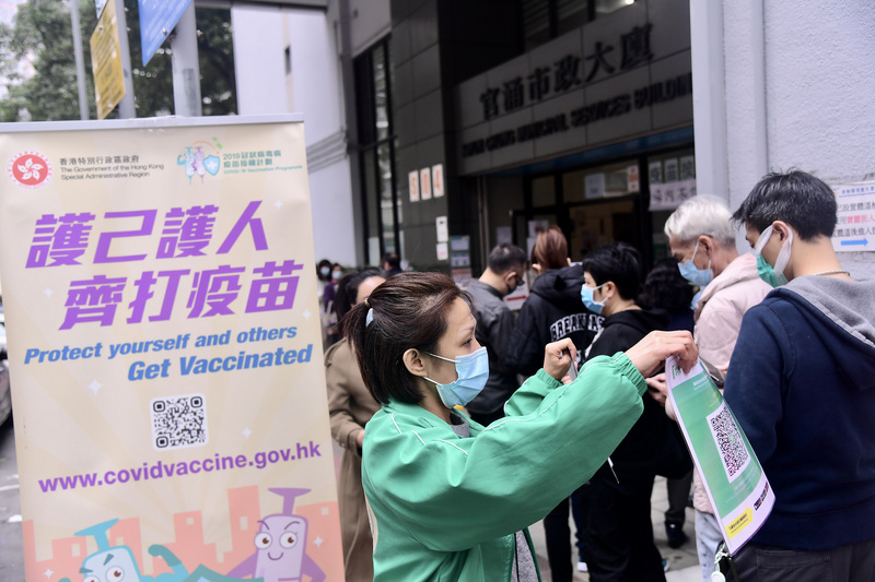 香港COVID-19疫情蔓延，分析指出，除Omicron變異株傳染力高外，年長者疫苗接種率低、防疫政策仍搖擺不定都是疫情傳播隱憂。圖為市民排隊接種疫苗。（中通社提供） (圖：中央社)