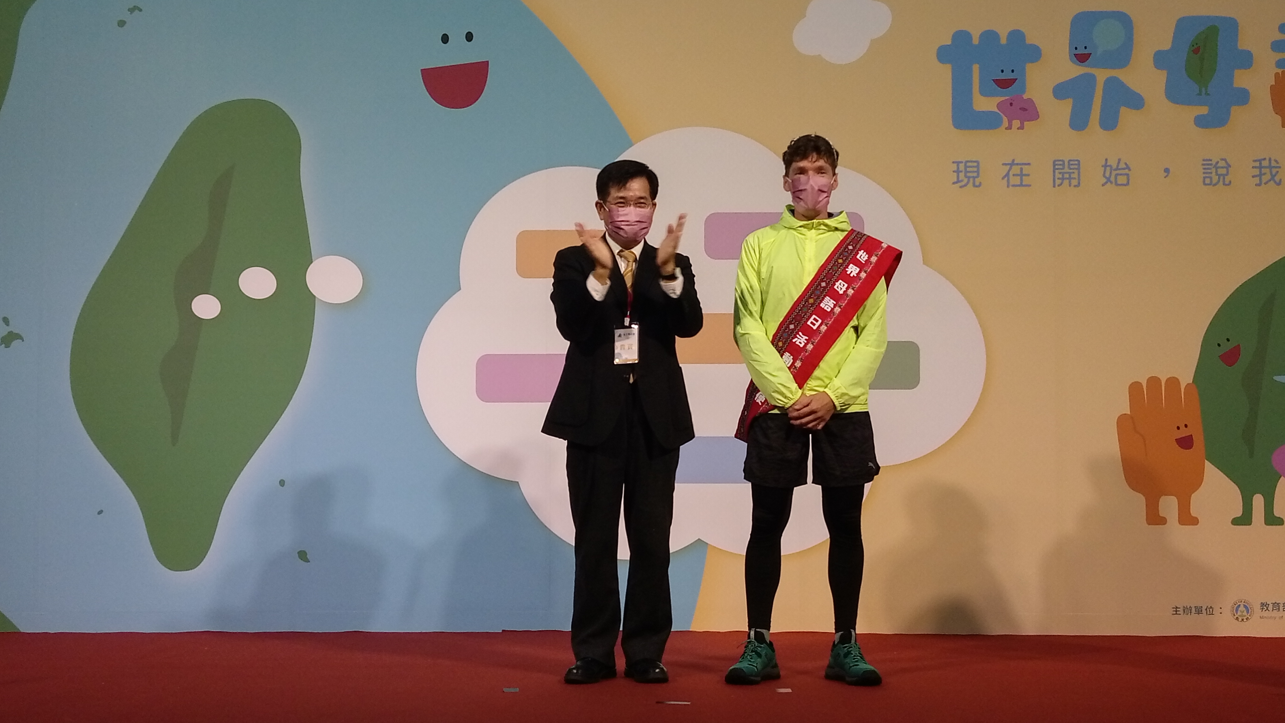 教育部長潘文忠(左)為吉雷米(右)戴上活動大使彩帶。(陳國維 攝)