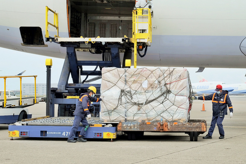 140.48萬劑COVID-19（2019冠狀病毒疾病）莫德納（Moderna）疫苗15日下午運抵台灣，由地勤人員將放置於貨艙的溫控櫃卸下，完成通關作業後經拖車送往貨物碼頭裝入冷鏈貨車，載往指定冷儲物流中心存放。 (圖：中央社)