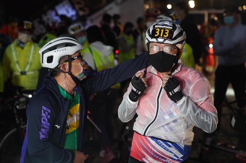 台北市長柯文哲（右）在市長任內最後一次挑戰騎單車「一日北高」，27日一早到北投關渡宮集合，出發前戴上安全帽與口罩等防護裝備。 (圖：中央社)