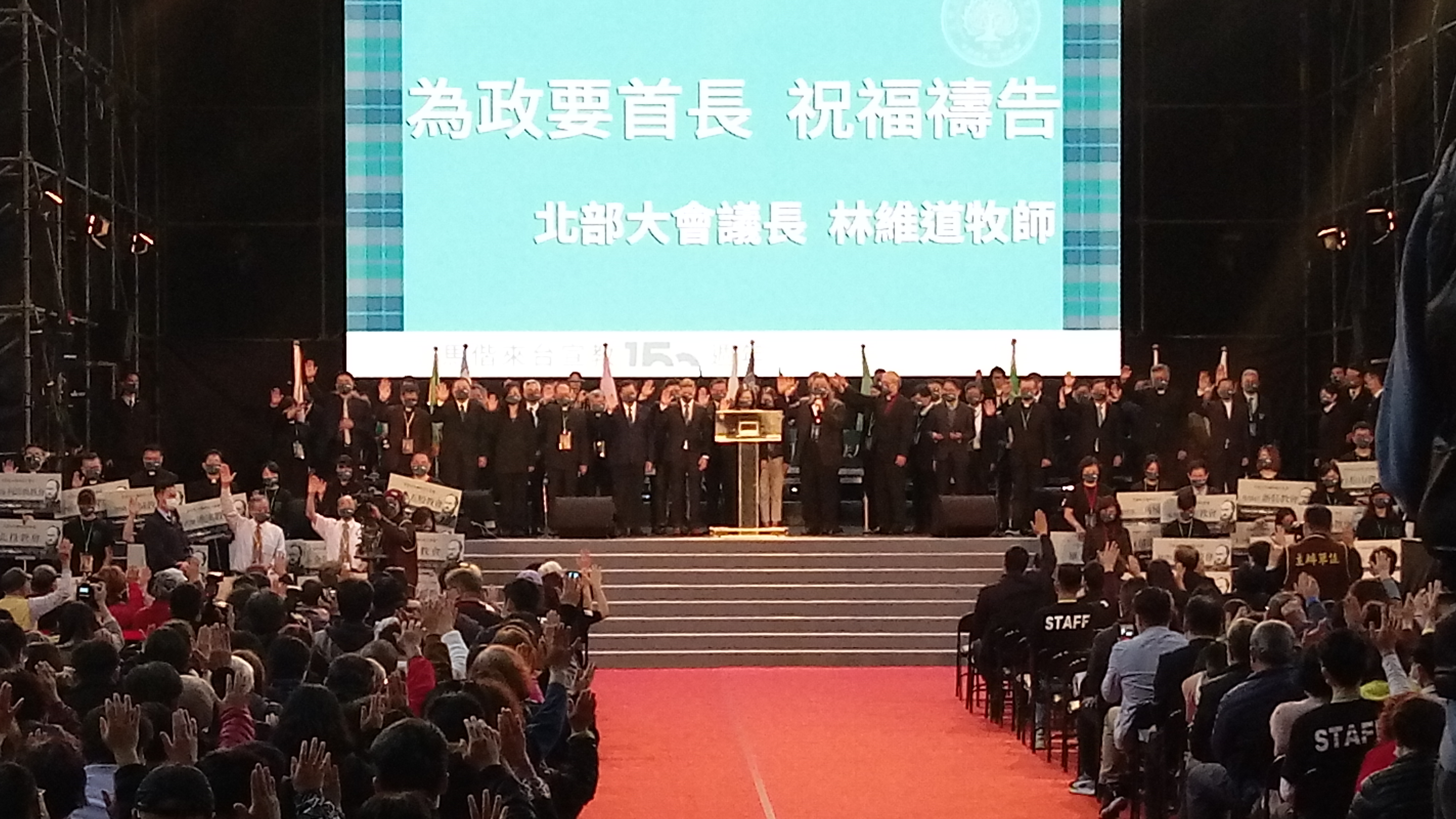 眾人在會場中舉起右手，為政要首長祝禱。(陳國維 攝)
