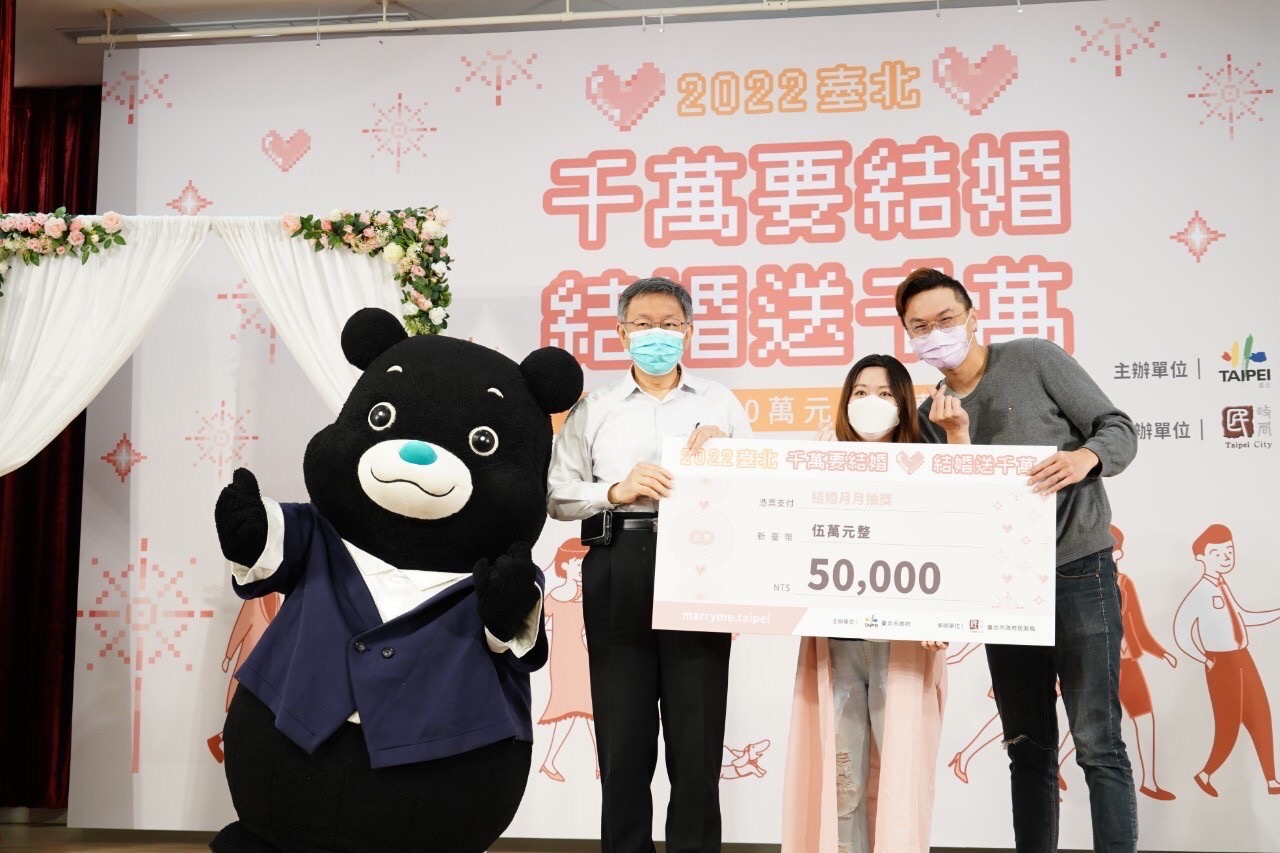 北市府祭出千萬獎金抽獎，鼓勵年輕人結婚。台北市長柯文哲(左二)特地頒發支票給得獎人。(北市府提供)