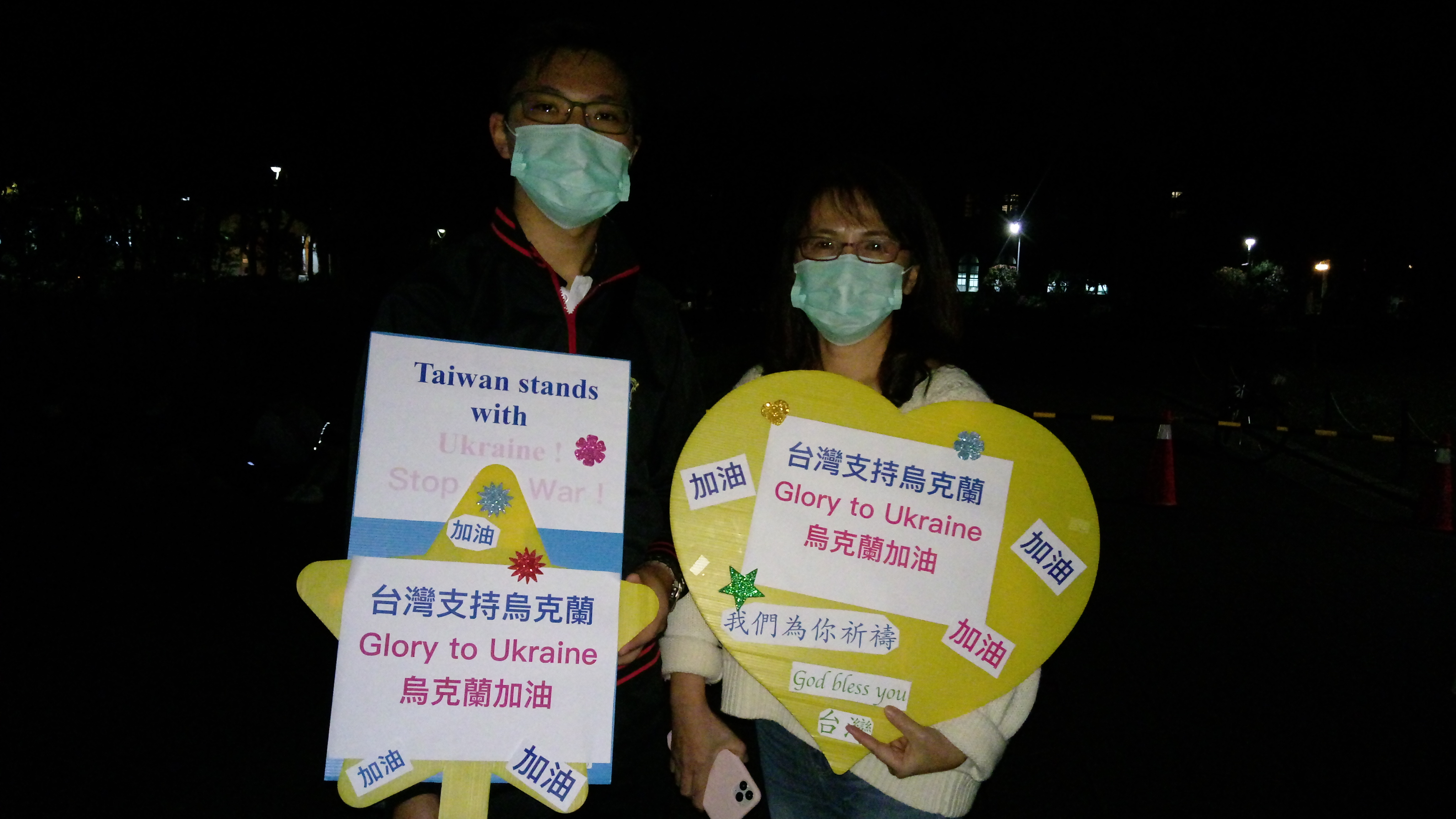 高中生黃子瑞(左)有著爸爸、媽媽(右)的支持，全家人自製標語看板一同力挺烏克蘭。(陳國維 攝)