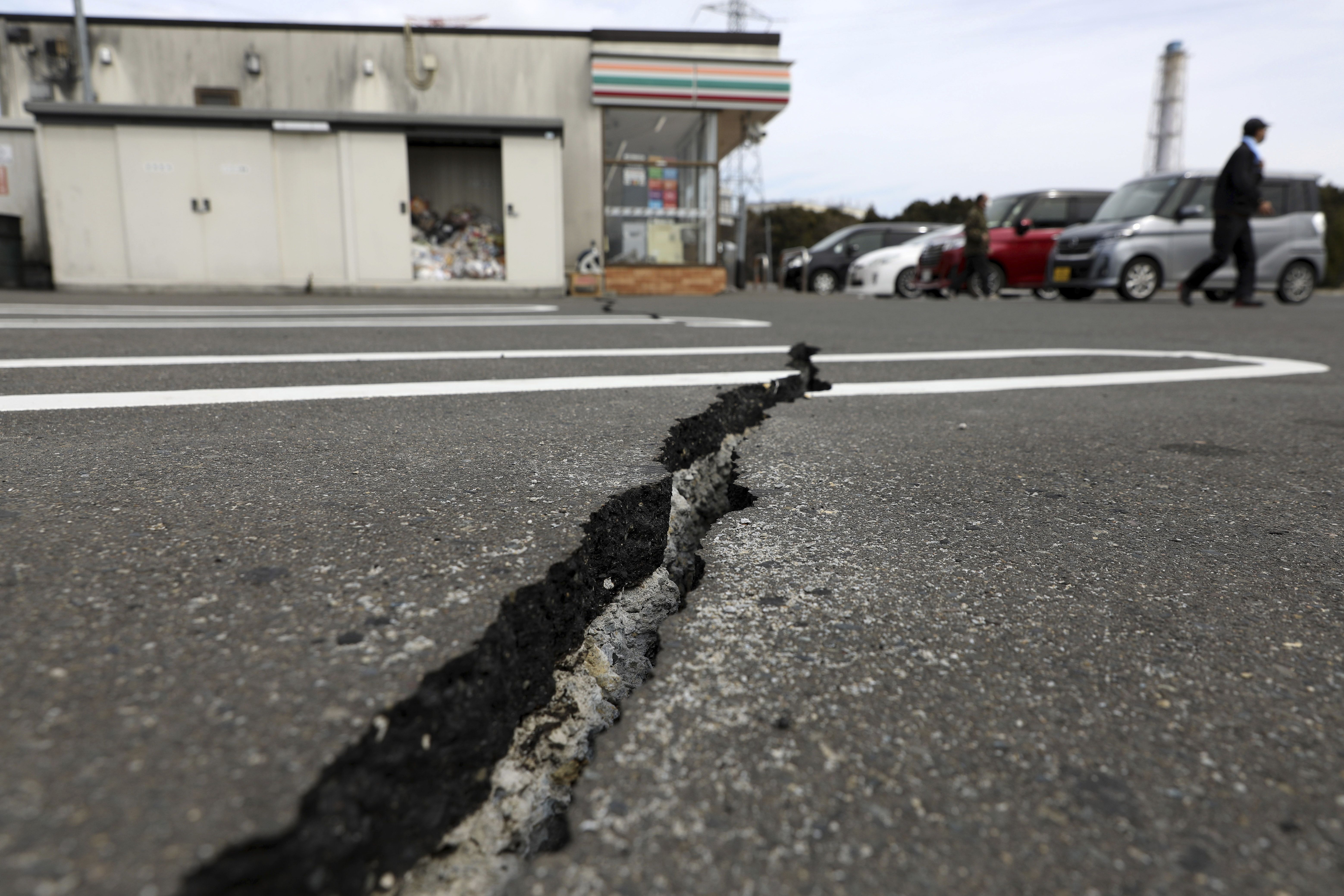 福島7.4強震，當地一間便利商店停車場的地面裂出一條大裂縫。  (美聯社/達志影像)