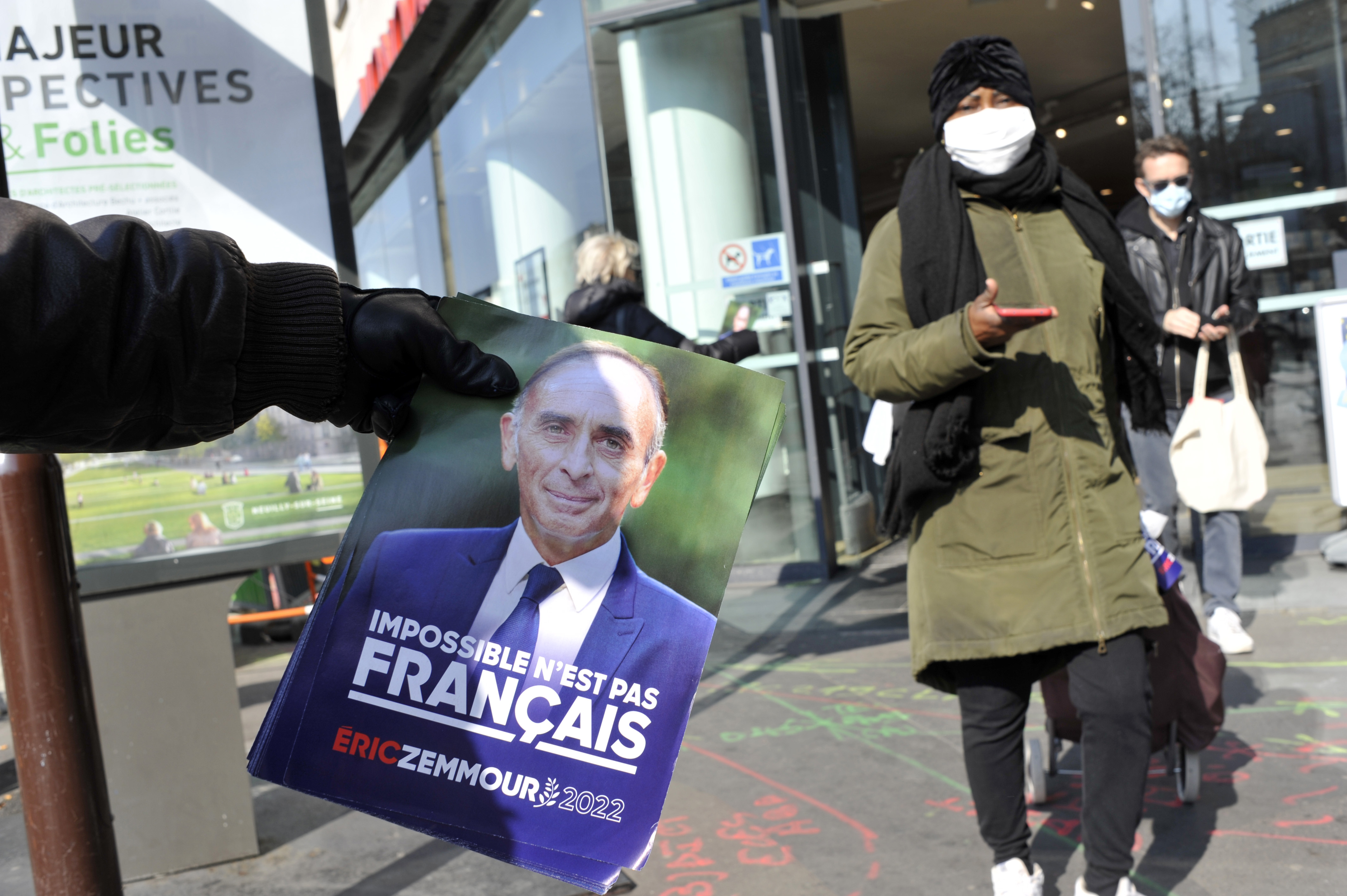 法國政府在總統大選前夕，宣布取消大部份的COVID-19管制措施，據最新通報顯示，確診人數升高36%。圖為巴黎街頭散發候選人之一澤穆爾(Eric Zemmour)傳單。(AFP)