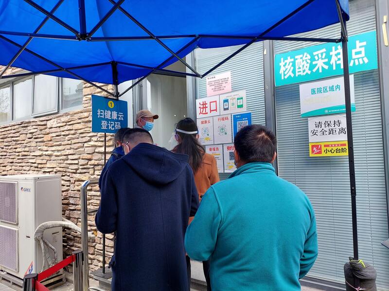 圖為上海當地一處社區衛生服務中心外，民眾等待做核酸檢測。 (圖：中央社)