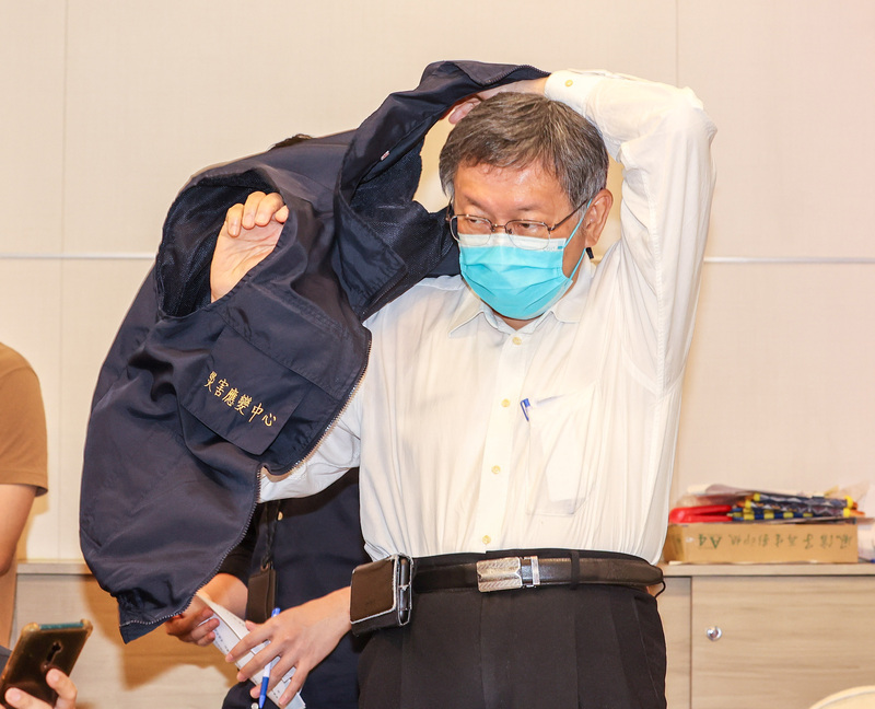台北市政府11日下午舉行COVID-19（2019冠狀病毒疾病）疫情記者會，市長柯文哲會前換上背心，準備向媒體簡報。 (圖：中央社)